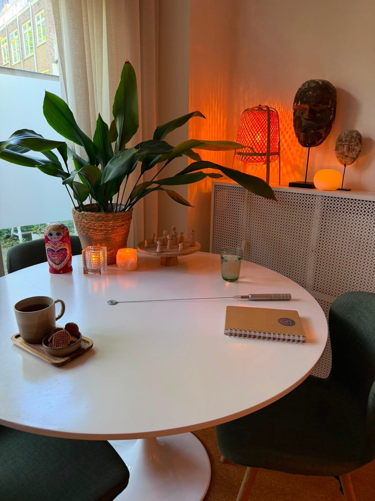Warme hoek van de Innerhouse praktijk in Amsterdam met tafel, plant en zacht licht